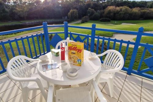 een witte tafel en stoelen op een balkon bij "SOLEIL DU GOLF" Appartement 5 personnes, vue golf, accès parc aquatique in Talmont