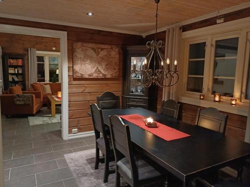 ein Esszimmer mit einem schwarzen Tisch und Stühlen in der Unterkunft Malangen Lodge in Mestervik