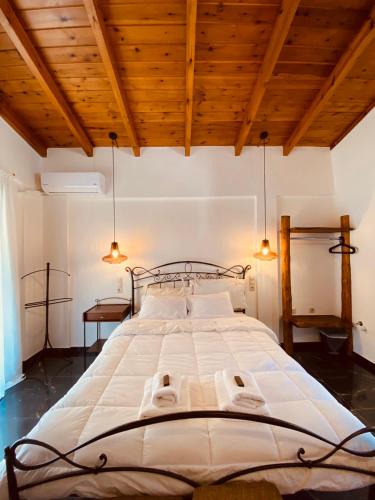 a large bed in a room with wooden ceilings at Μούσες in Kalavrita