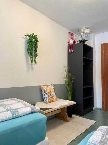 a bedroom with a bench and a plant on the wall at Appartementhaus FICHTERN in Sankt Johann in Tirol