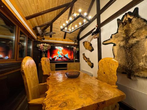 a dining room with a wooden table and a tv at Ice Dream Apartmani in Kopaonik