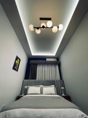 a bedroom with a bed and a ceiling at Garden Boutique Hotel in Elbasan