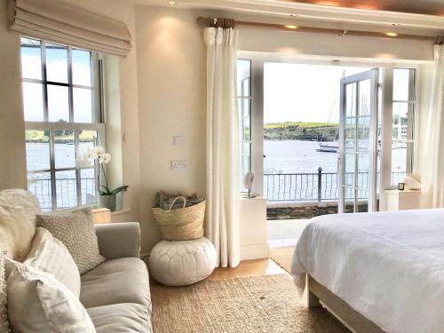 キンセールにあるWaterfront Chic Studioのベッドがあり水辺の景色が見える寝室