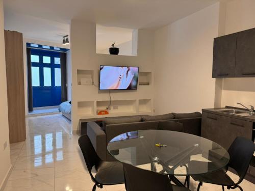 salon z kanapą i szklanym stołem w obiekcie One in Se7en w mieście St. Julian’s