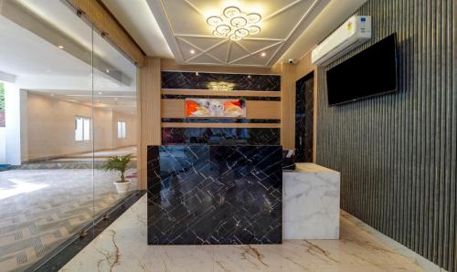 a lobby with a flat screen tv and a glass wall at Treebo Trend Raj Palace in Varanasi