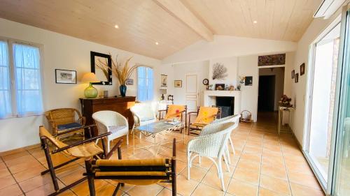 un salon avec des chaises et une table dans l'établissement Maison familiale en plein cœur de la Couarde sur Mer, à La Couarde-sur-Mer