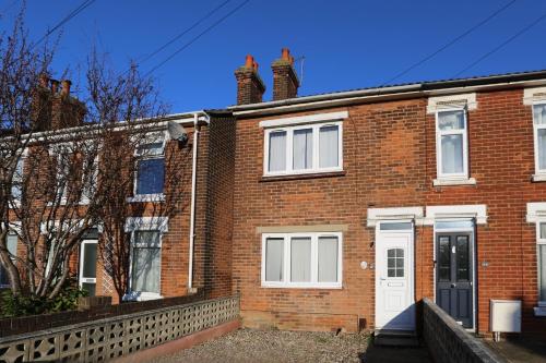 a red brick house with a white door at Modern 5 Bed House with Parking in Colchester