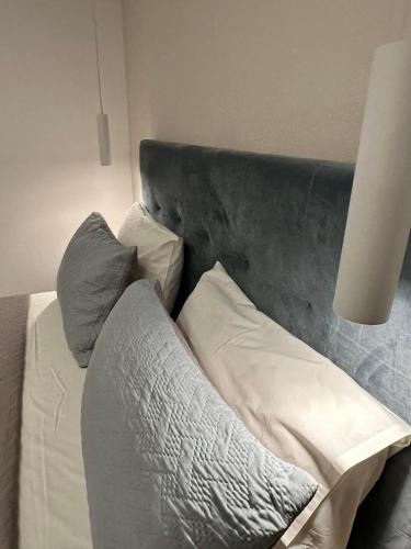 a bedroom with a bed with a gray headboard and pillows at Castro Hotel in Amoudara Herakliou