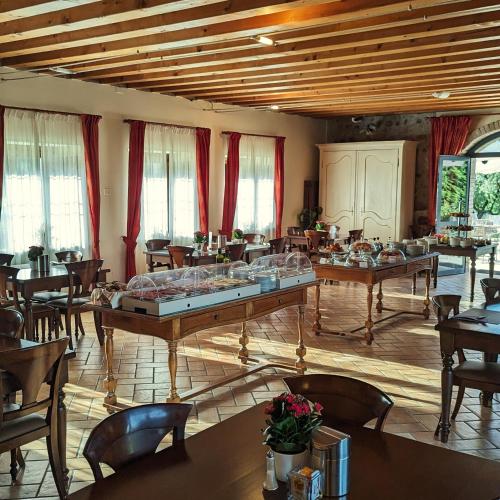 une grande pièce avec des tables, des chaises et des fenêtres dans l'établissement Tenuta La Presa, à Caprino Veronese