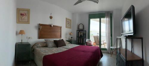 een slaapkamer met een bed met een paarse deken bij 1ª línea mejor playa de Mojacar in Mojácar