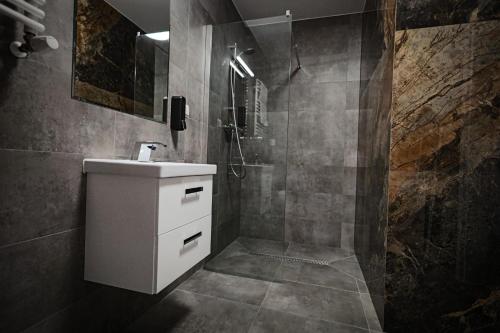 y baño con lavabo blanco y ducha. en Reymonta 22 Apartamenty en Opole