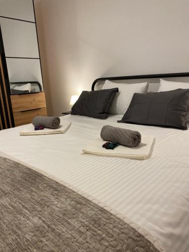 a bed with two pillows on top of it at Apartman Alexandra in Ruma