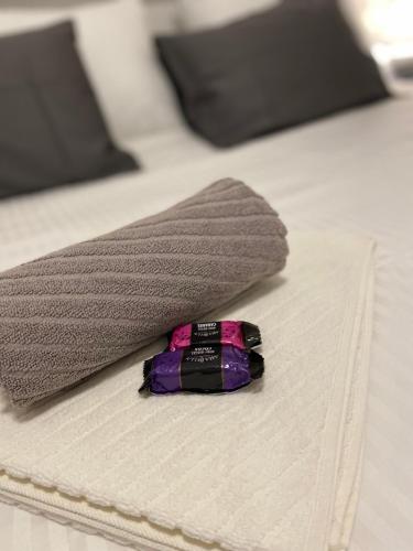 a comb on a bed next to two towels at Apartman Alexandra in Ruma