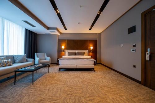 um quarto de hotel com uma cama e um sofá em B'İSTANBUL HOTEL em Istambul