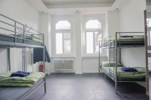 Cette chambre comprend 3 lits superposés et 2 fenêtres. dans l'établissement Apartment with balkon, à Wuppertal
