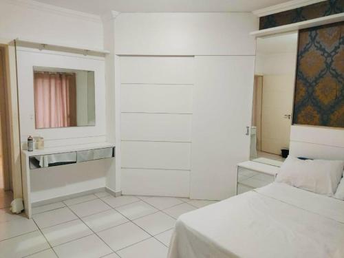 a white bedroom with a bed and a mirror at SOBRADO INGLESES in Florianópolis