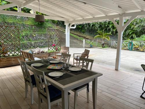 a dining table and chairs on a patio at Ti Kay Bonè Bellefontaine in Fond Belle Fontaine