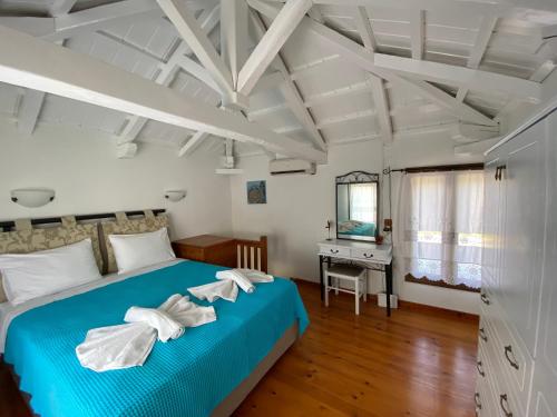 1 dormitorio con cama azul y escritorio en Agnanti Villas 2, en Isómata