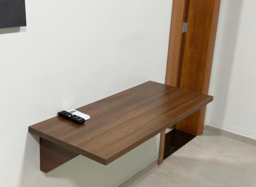 a wooden table with a remote control sitting on it at Hotel 7 Quedas in Guaíra
