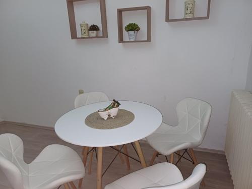 una mesa blanca y sillas en una habitación en Apartment Green Free private parking en Novi Sad