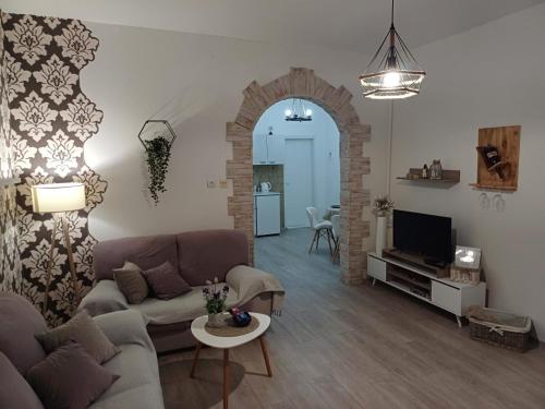 a living room with a couch and a tv at Apartment Green Free private parking in Novi Sad