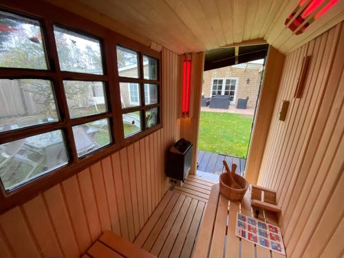 uma vista interior de um pequeno quarto com janelas em Spaanse Bungalow nabij Amsterdam with Sauna and steam sauna em Vijfhuizen