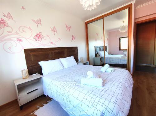 een slaapkamer met een bed met roze vlinders aan de muur bij AL-Formoso in Vilar Formoso