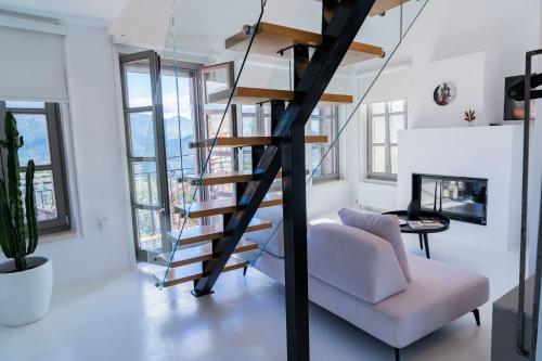 uma sala de estar com uma escada em espiral e um sofá branco em Clock Tower em Arachova
