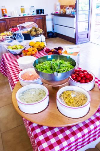 a table filled with bowls of vegetables and other foods at Hotel Il Castello in Pozzolengo