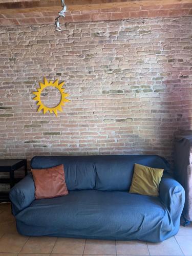 a blue couch against a brick wall with a sun on it at Flat Plaza de España BCN in Barcelona