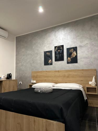 - une chambre dotée d'un lit avec 4 photos sur le mur dans l'établissement B&B Residenza De Rose, à Cosenza