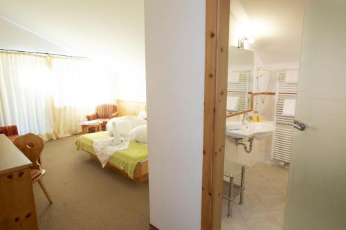 a bedroom with a bed and a sink in a room at Hotel Vernagt in Senales