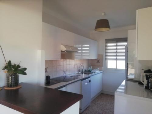 une cuisine avec des armoires blanches et un évier dans l'établissement Résidence Stella Maris, à Antibes