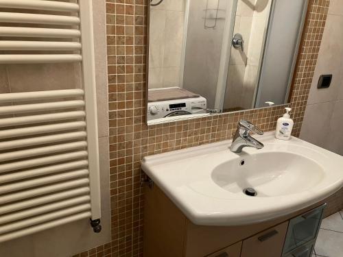 uma casa de banho com um lavatório e um espelho em Casa Ciotti Appartamento in centro ad Aosta CIR 0124 em Aosta