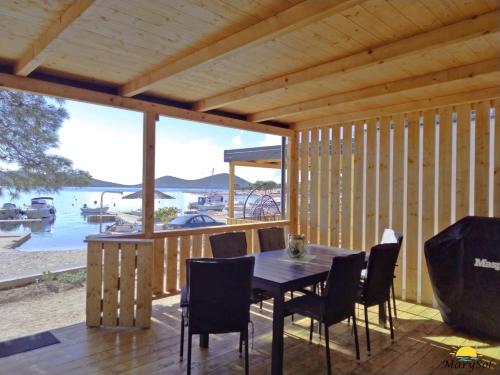 ein Holzhaus mit einem Tisch und Stühlen auf einer Terrasse in der Unterkunft First Row to the sea Mobilehome in Drage
