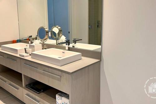 a bathroom with two sinks and a large mirror at Luxury apartment with endless ocean views -Daily resort fee and parking not included- in Hollywood