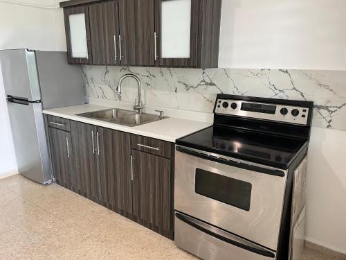 a kitchen with a stainless steel stove and a sink at Villa del Carmen Boqueron in Cabo Rojo