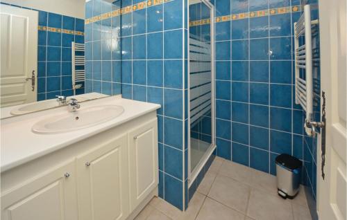 エーグ・モルトにあるNice Home In Aigues-mortes With 3 Bedrooms And Wifiの青いタイル張りのバスルーム(シンク、シャワー付)