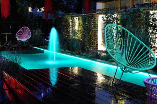 a fountain in the middle of a pool at night at Nala Individuellhotel in Innsbruck