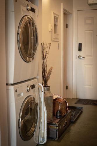 a washer and dryer sitting next to a door at 2 Full Beds, Free Parking Underground Heated, Rogers Place, 1 Bedroom Condo Downtown Central in Edmonton