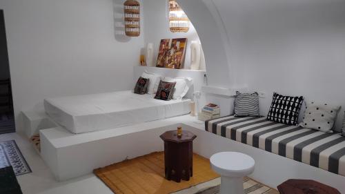Sala de estar con 2 camas y mesa en Maison d’hôte, Djerba 