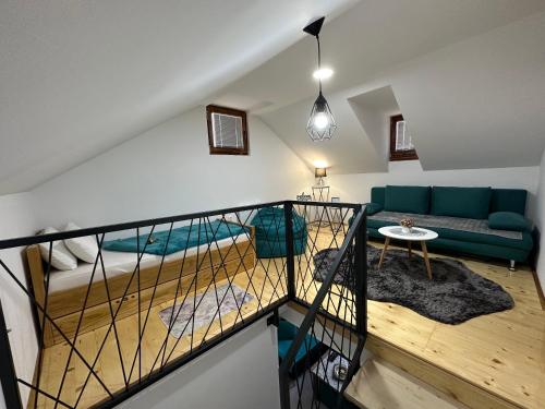 - un salon avec un canapé vert et un lit dans l'établissement Snjezna kuca Rakovac, à Pale