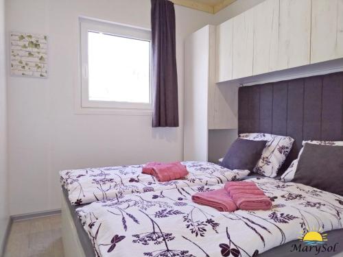 ein Bett mit zwei Kissen darauf in einem Schlafzimmer in der Unterkunft First Row to the sea Mobilehome in Drage