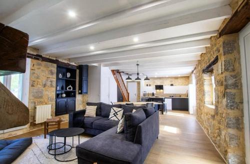 ein Wohnzimmer mit einem Sofa und einem Tisch in der Unterkunft Gîte Le Perche Rose in Eymet