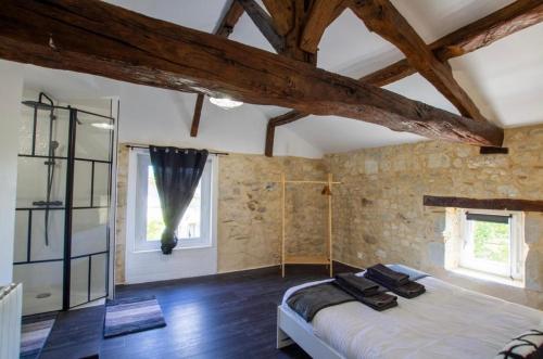 Un dormitorio con una cama grande y una ventana en Gîte Le Perche Rose, en Eymet