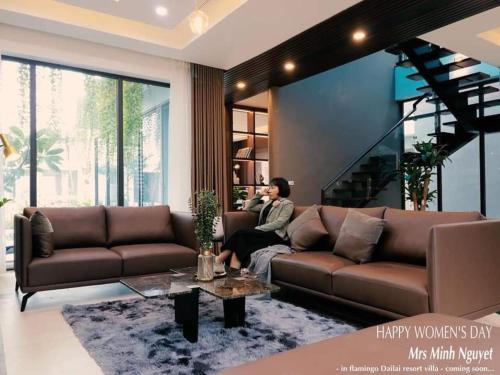 a man sitting on a couch in a living room at Moon Villa E2.10 Venus by Flamingo Đại Lải in Phúc Yên