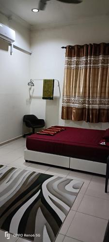 een kamer met een bed en een raam met een gordijn bij Rawynaa Segamat Homestay 