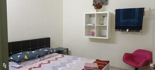 een slaapkamer met een bed en een witte kast bij Rawynaa Segamat Homestay 