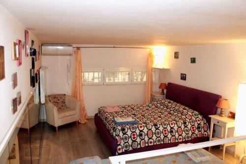 1 dormitorio con 1 cama y 1 silla en PURPLE HOUSE, en Roma