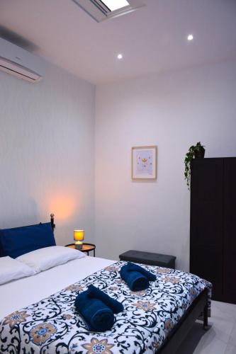 a bedroom with a bed with two blue pillows on it at Casa Chloé - vicino al Porto e Basilica San Nicola in Bari